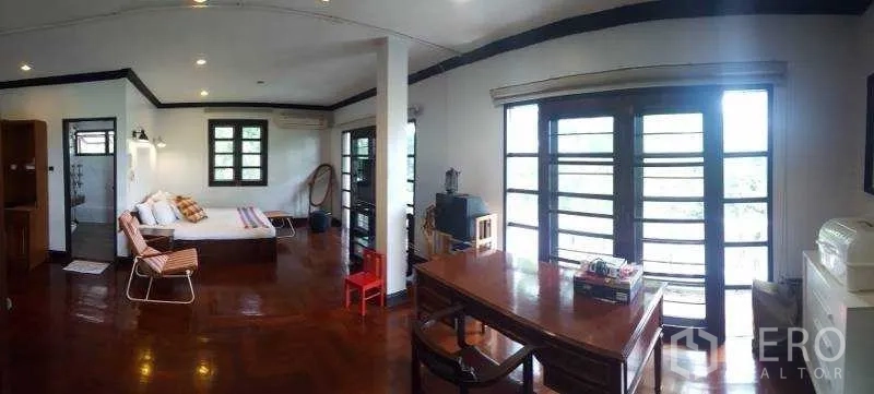Detached House for rent in Bang Phli, Samut Prakan - Upstairs family room with balcony doors, desk and glossy wood floors.