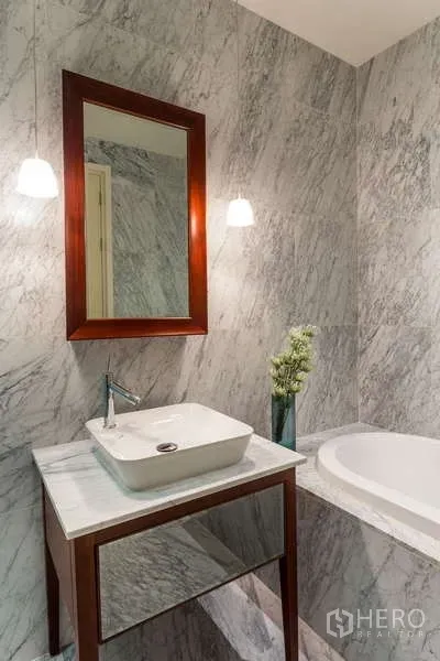 公寓 出租在Watthana, Bangkok - 近景：台上盆洗手台、木框镜、吊灯与大理石浴缸。