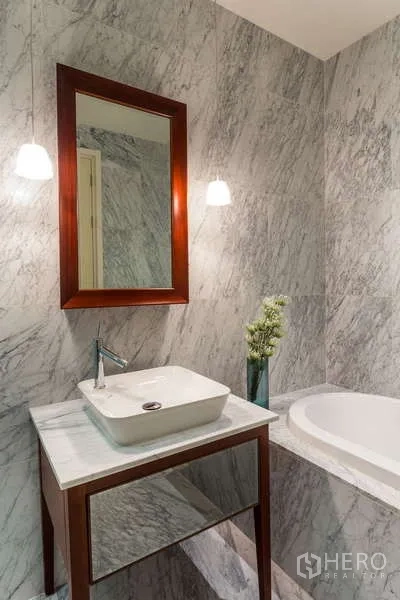 公寓 出租在Watthana, Bangkok - 近景：台上盆洗手台、木框镜、吊灯与大理石浴缸。