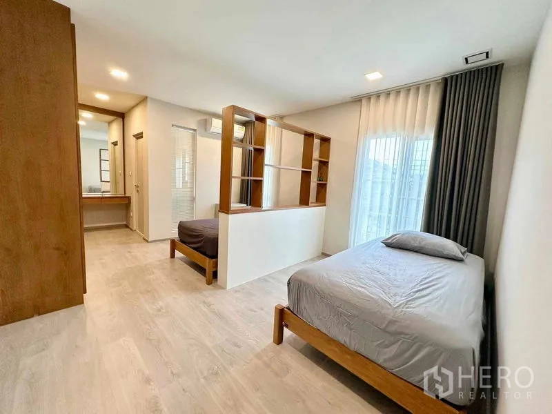 独立式住宅 出租或出售在Prawet, Bangkok - 楼上宽敞卧室，木架隔断分出两处睡眠区，落地窗带窗帘。