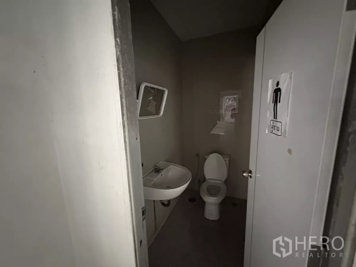 คลังสินค้า ให้เช่าในBang Phli, Samut Prakan - ห้องน้ำใกล้ชิด แสดงโถสุขภัณฑ์ อ่างล้างมือ และป้ายหน้าประตู.
