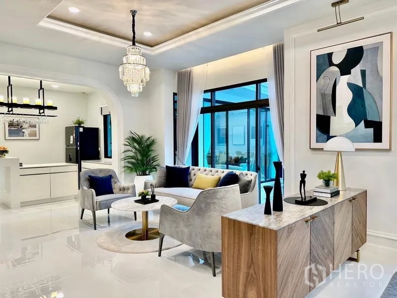 บ้าน ให้เช่าในLat Krabang, Bangkok - มุมนั่งเล่นติดซุ้มโค้งเข้าสู่ครัว ตู้ลิ้นชักและงานศิลปะตกแต่ง