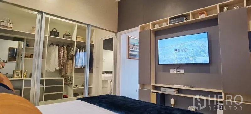 联排别墅 出租在Prawet, Bangkok - 卧室视角展示电视墙、推拉衣柜与套卫通道。