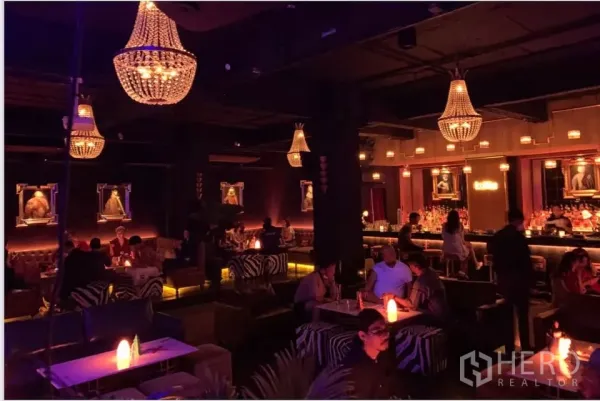 พื้นที่ขายปลีก ให้เช่าในWatthana, Bangkok - เลาจน์ไฟสลัวพร้อมโคมระย้า โต๊ะสีขาว และที่นั่งลายม้าลาย