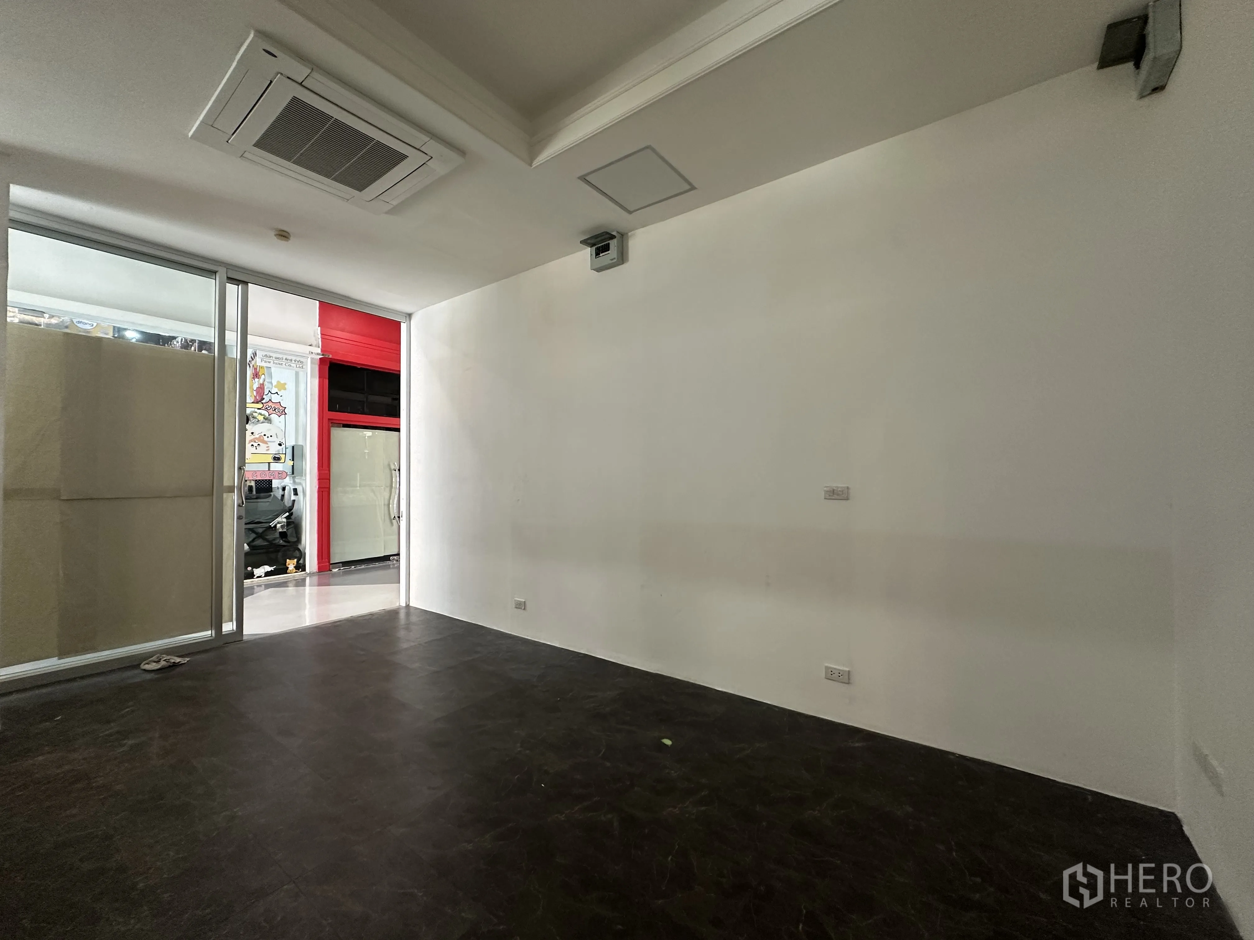 零售空间 for rent in Khlong Toei, Bangkok - 店铺后侧一角，白色墙面、天花板嵌入空调，并可见室内走廊。