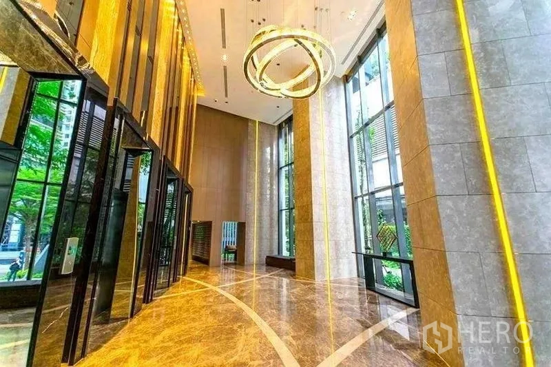 公寓 出租在Khlong Toei, Bangkok - 豪华大堂，铺大理石地面，通高落地窗与环形吊灯。