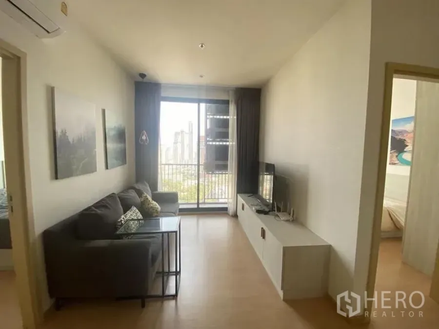 Condominium for rent in Watthana, Bangkok - Another view of the living room opening to a balcony overlooking Ekkamai’s cityscape.