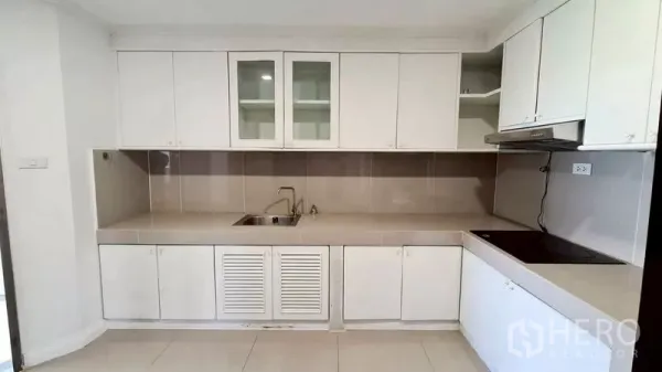 คอนโด ให้เช่าในWatthana, Bangkok - ครัวพร้อมเตาและฮูด ตู้เก็บของสีขาวจำนวนมากและผนังกระเบื้อง