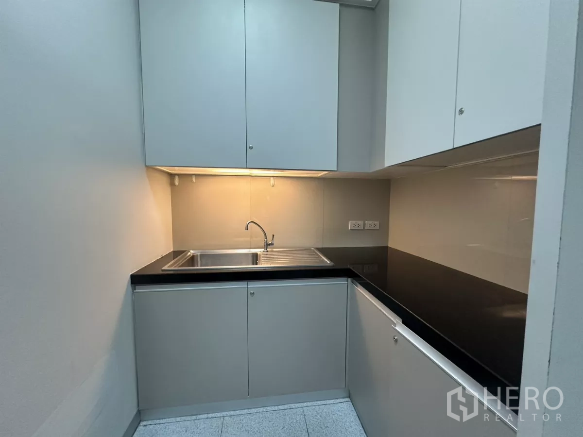 办公空间 出租在Watthana, Bangkok - 紧凑茶水间，带水槽、吊柜与黑色台面。