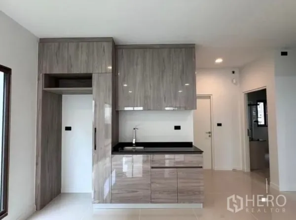 Detached House for rent in Bang Kapi, Bangkok - Built-in pantry with high-gloss wood cabinets and black countertop.