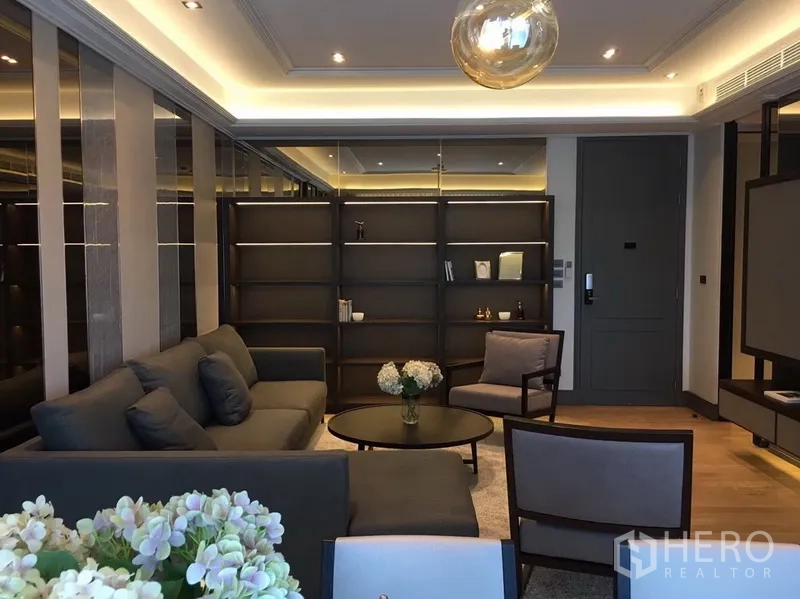 คอนโด ให้เช่าในWatthana, Bangkok - ห้องนั่งเล่นพร้อมโซฟา เก้าอี้อาร์มแชร์ ชั้นวางบิวท์อิน และไฟซ่อนฝ้า