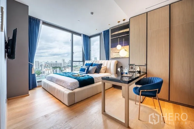 Condominium for rent or sale in Khlong Toei, Bangkok - Bedroom with city view, built-in wardrobe and compact work desk.