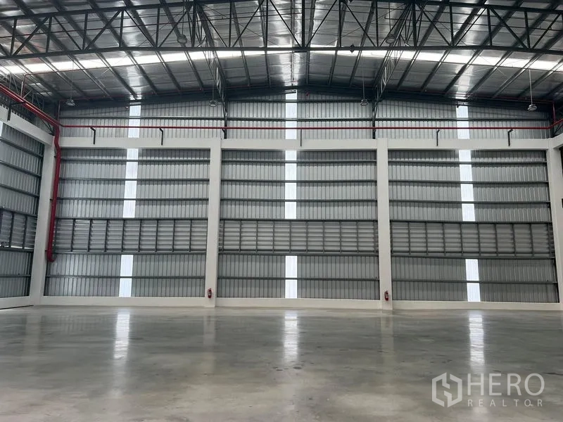 Factory for rent in Bang Pakong, Chachoengsao - Clear-span production floor featuring insulated roof, louvered ventilation and multiple fire hose reels.
