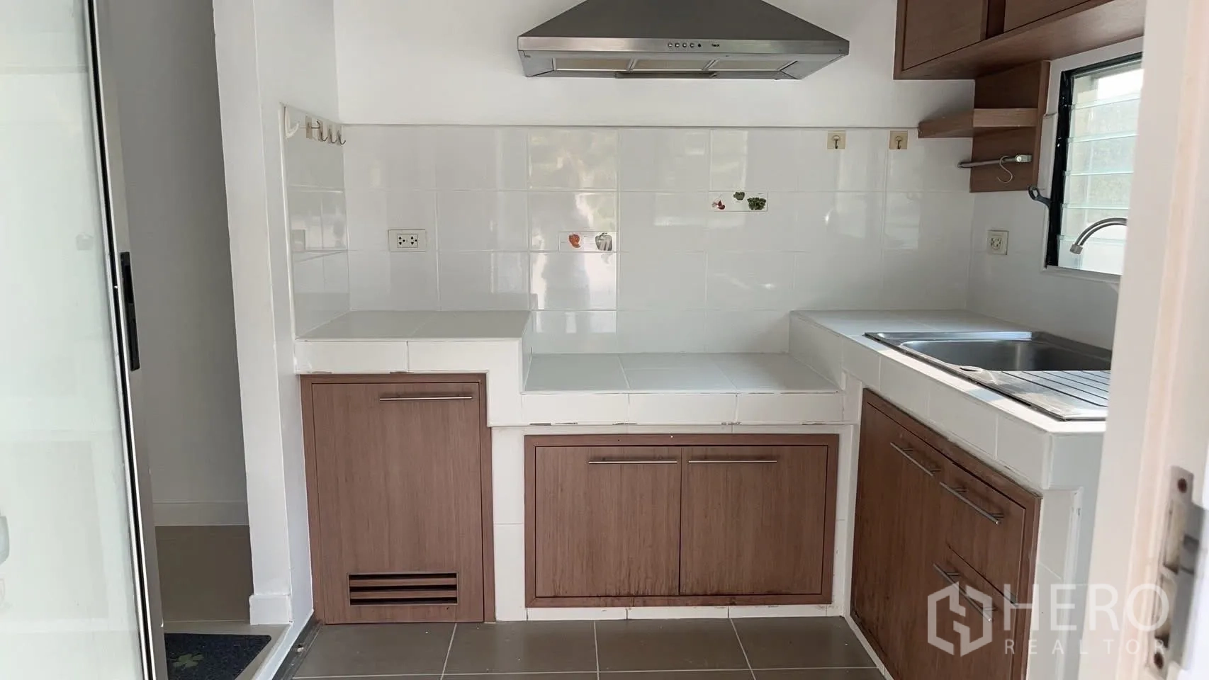 独栋房屋 for rent in Bang Na, Bangkok - 厨房配抽油烟机、瓷砖台面、水槽与木质橱柜。