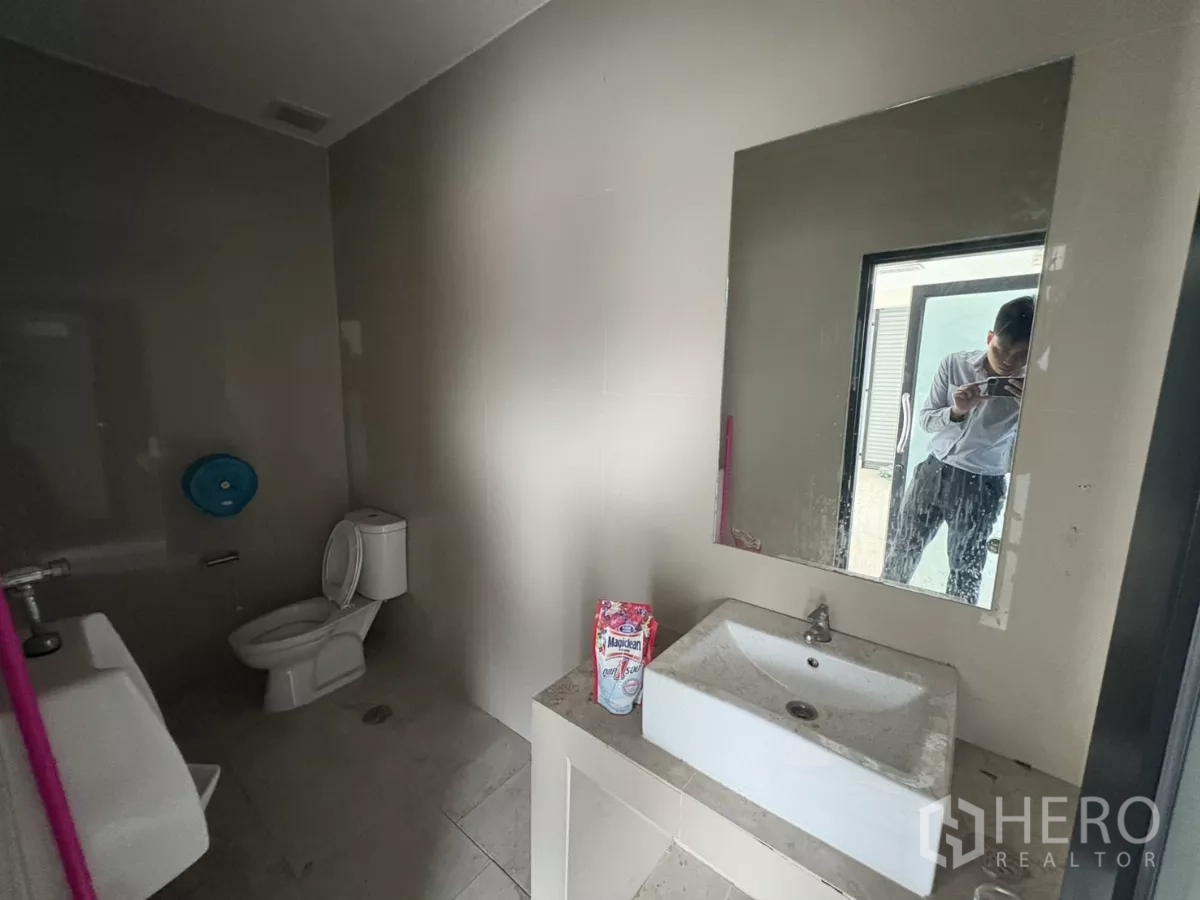 Warehouse for rent in Bang Phli, Samut Prakan - Restroom with toilet, sink and mirror inside the office area.
