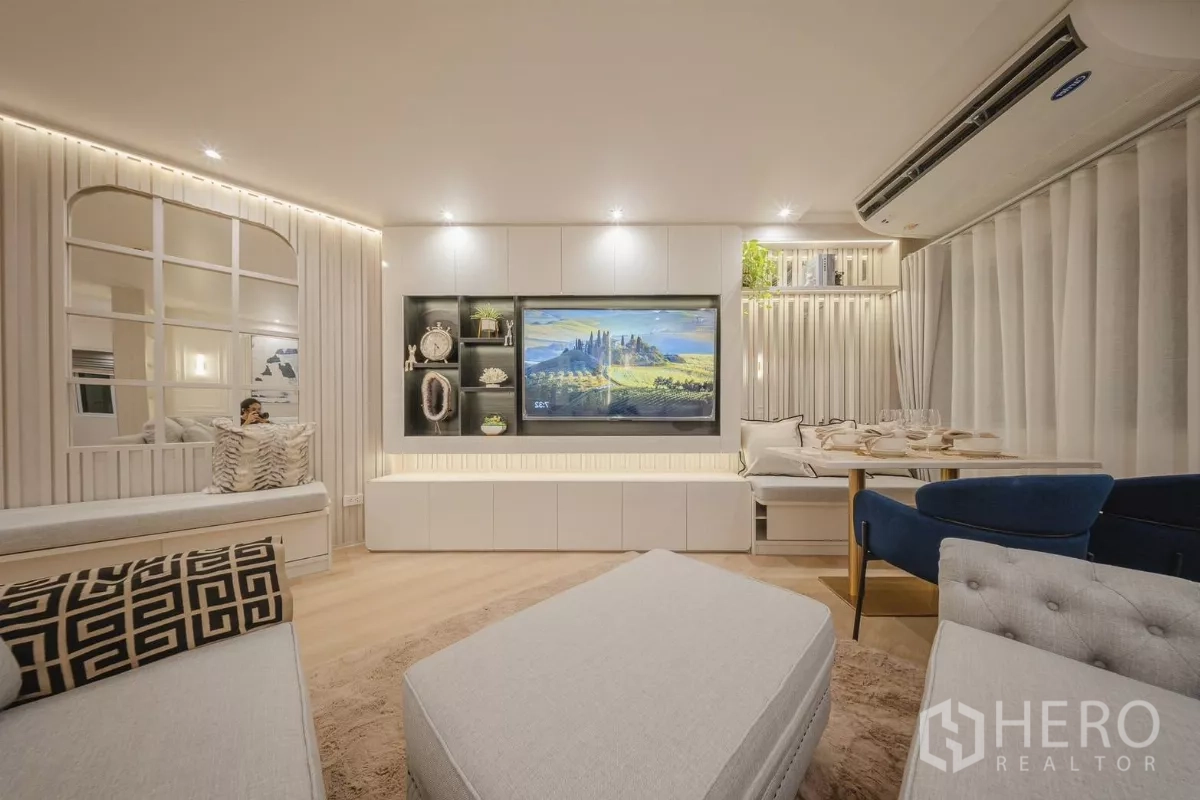 Condominium for rent in Yan Nawa, Bangkok - Media wall and dining banquette with floor-to-ceiling curtains in the living room.