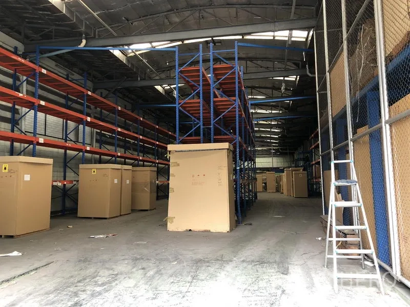 Factory for rent in Lam Luk Ka, Pathum Thani - Indoor warehouse fitted with tall blue pallet racking and large cardboard crates.