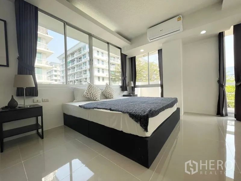 คอนโด for rent in Khlong Toei, Bangkok - ห้องนอนมีหน้าต่างมุมมองกว้างสองด้าน เห็นต้นไม้และอาคาร
