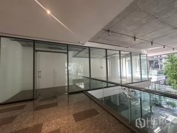 零售空间 出租 - 帕卡隆上层走廊的玻璃门面商铺，花岗岩地面与裸露混凝土顶。