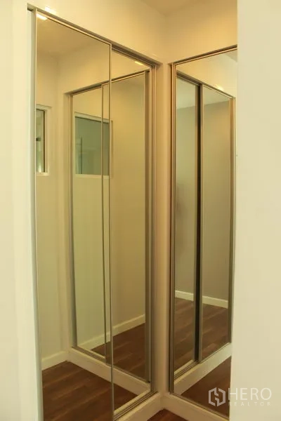 Condominium for rent or sale in Watthana, Bangkok - Corner wardrobe with mirrored sliding doors creating a compact dressing area.