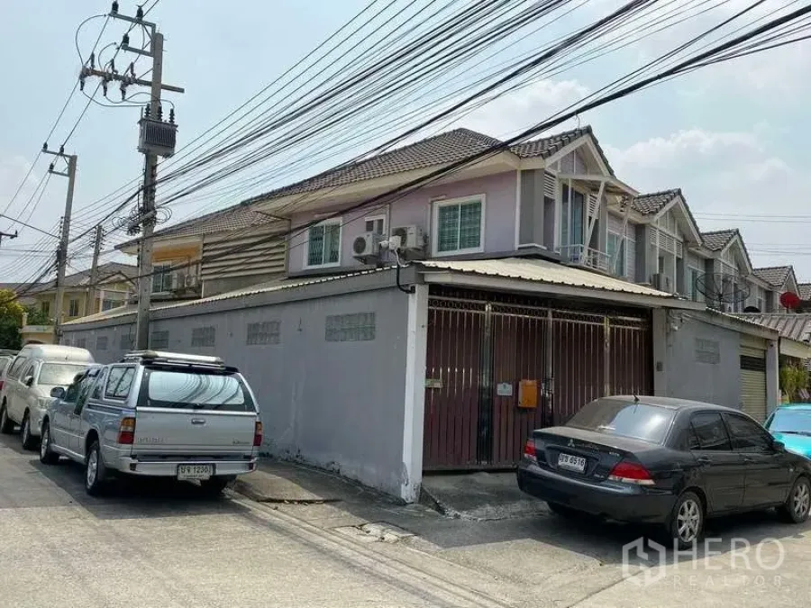 联排别墅 出售在Samut Prakan - 两层转角联排别墅，带上锁车库门和高围墙，瓷瓦屋顶，位于北榄府邦博安静住宅街道旁。