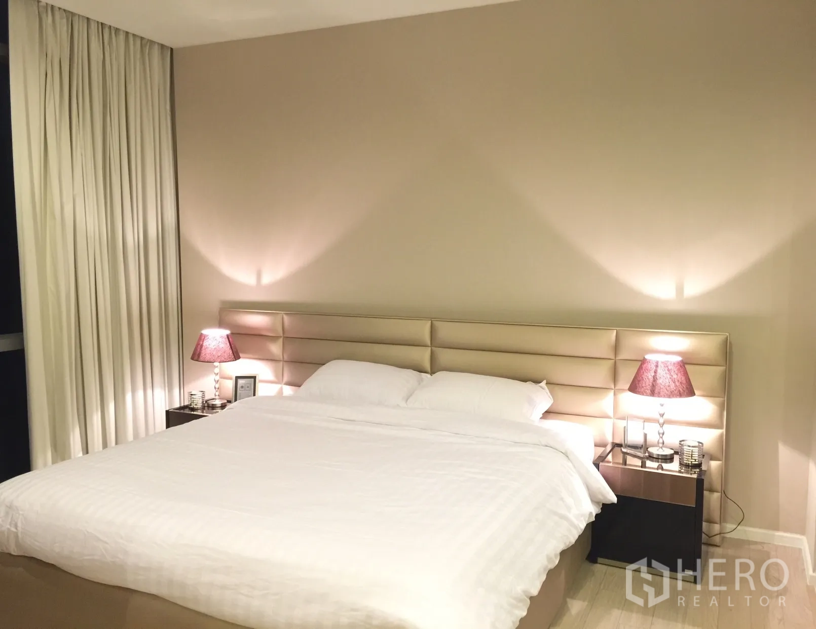Condominium for rent or sale in Watthana, Bangkok - Serene bedroom with upholstered headboard, bedside lamps and neutral tones.