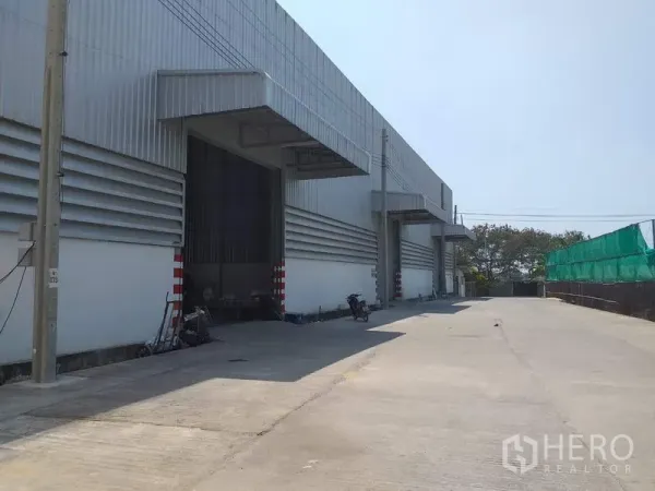 货栈 出租在Pak Kret, Nonthaburi - 仓库外观，带遮雨装卸月台与宽阔混凝土车道（帕克烈）