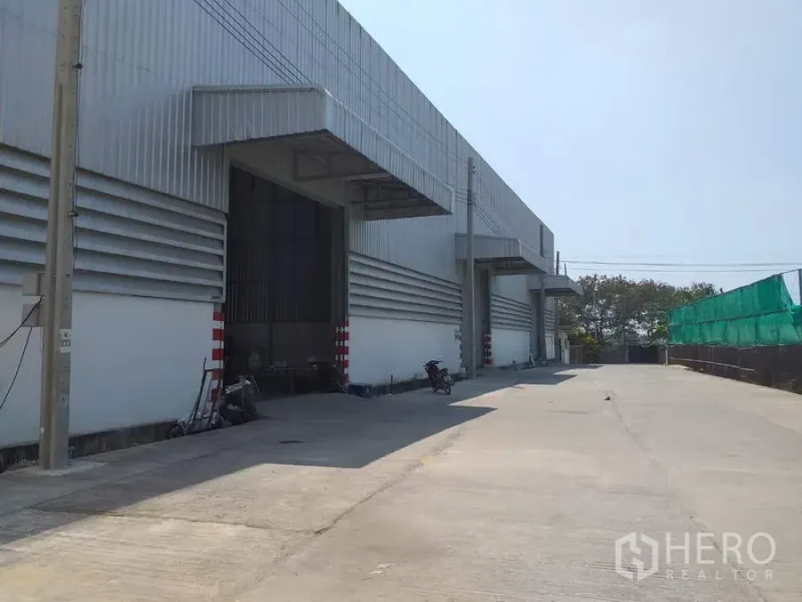 货栈 出租在Pak Kret, Nonthaburi - 仓库外观，带遮雨装卸月台与宽阔混凝土车道（帕克烈）