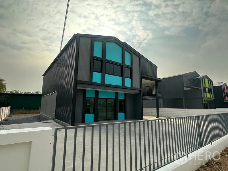 工厂 出租或出售在Bang Bua Thong, Nonthaburi - 一排新建小型工厂，前方设围栏与宽敞停车区。