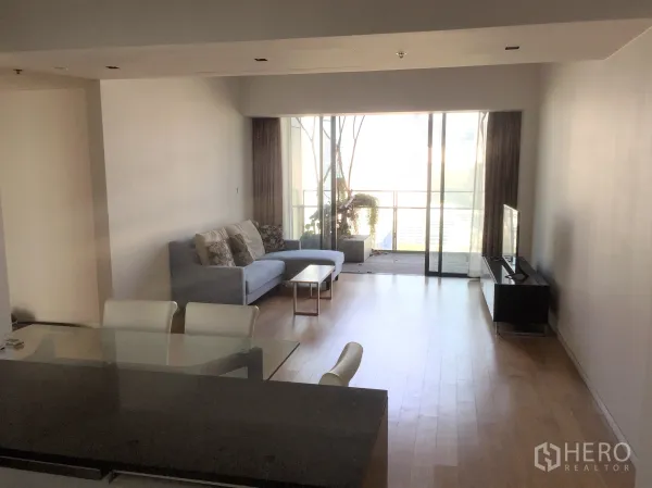Condominium for sale in Sathon, Bangkok - Open‑plan living and dining area with sofa, TV console and balcony city view.