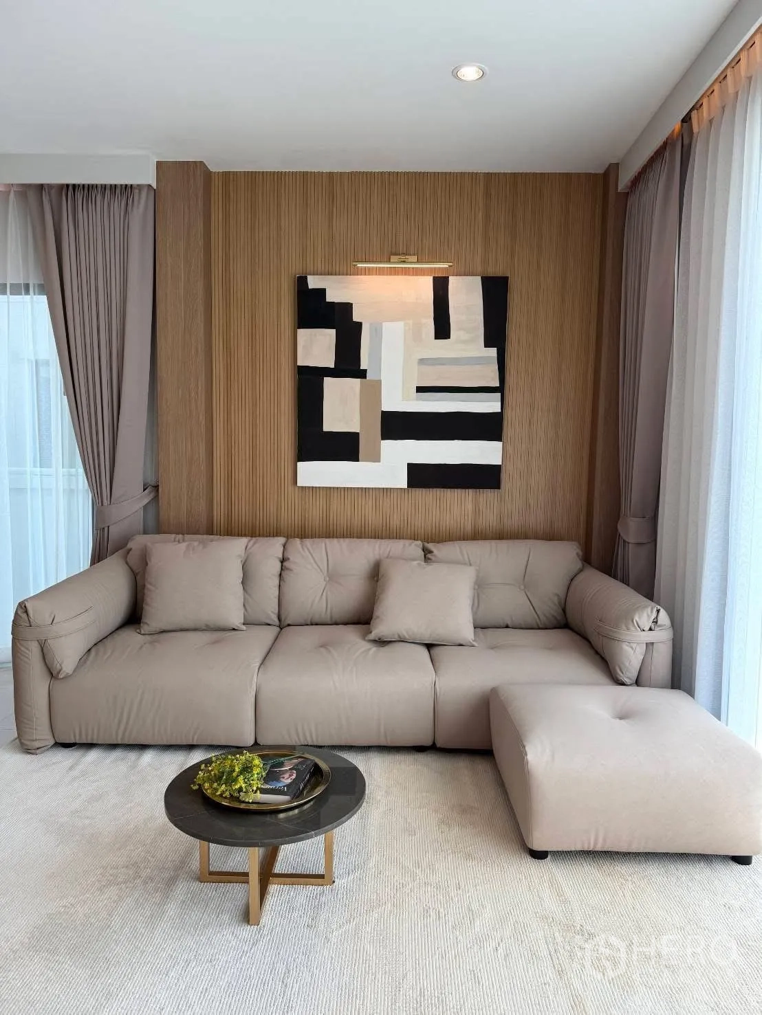 Detached House for rent in Bang Phli, Samut Prakan - Corner lounge with a taupe sectional sofa, ottoman, small round coffee table, and framed art.
