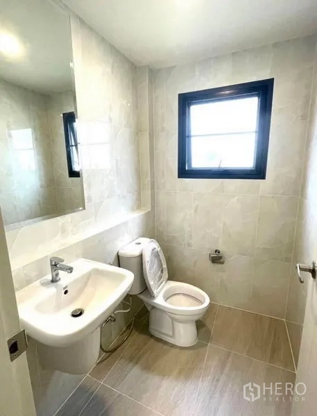 Detached House for rent - Compact guest bathroom with window, large mirror, white sink and toilet.