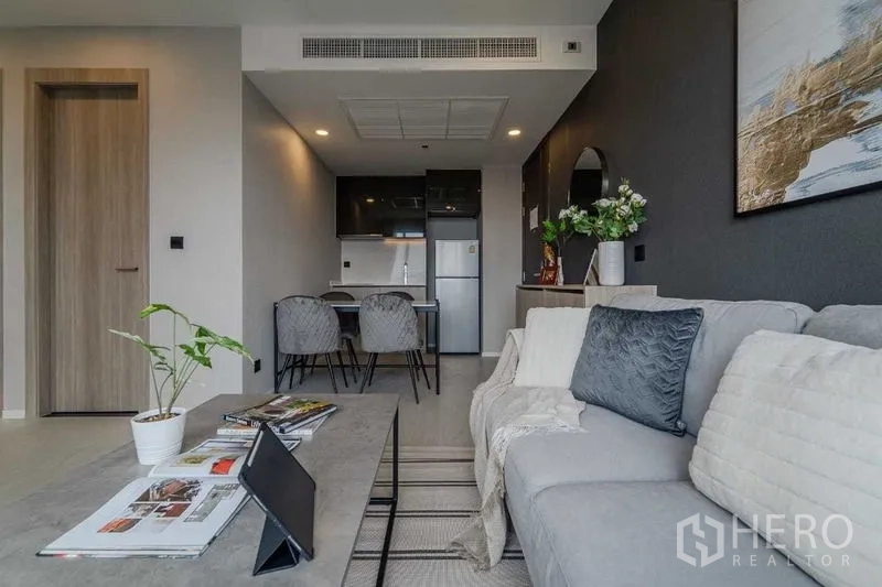 คอนโด ให้เช่าในPathum Wan, Bangkok - โซนนั่งเล่นมองไปยังครัวและชุดทานข้าว โทนเทานุ่มสบายตา