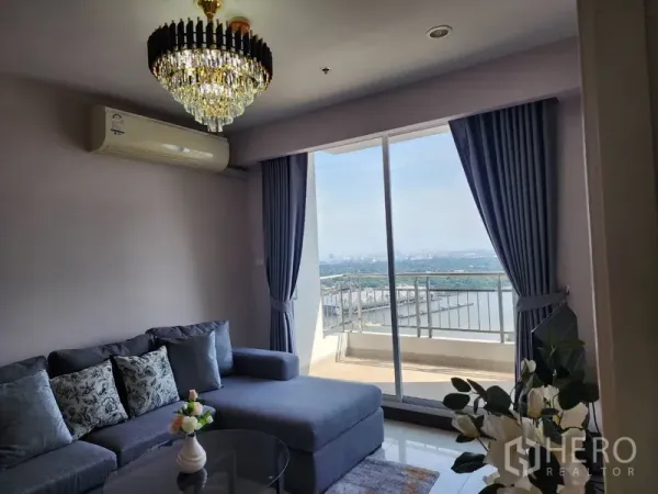 公寓 出租在Yan Nawa, Bangkok - L型沙发面向落地推拉门，连通阳台，可观河景，蓝色窗帘