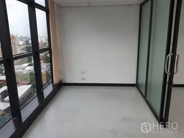Office Space for rent in Watthana, Bangkok - Corner workspace with tall windows and a glass door, featuring urban views.