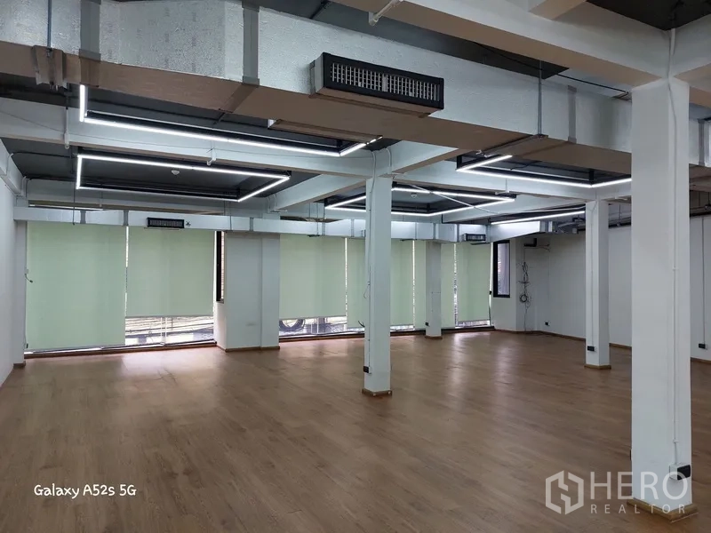 สำนักงานที่บ้าน ให้เช่าในKhlong Toei, Bangkok - ชั้นสำนักงานโอเพนสเปซกว้าง พื้นลายไม้ เสาโครงสร้าง เพดานลอยเดินท่อและไฟเส้น LED