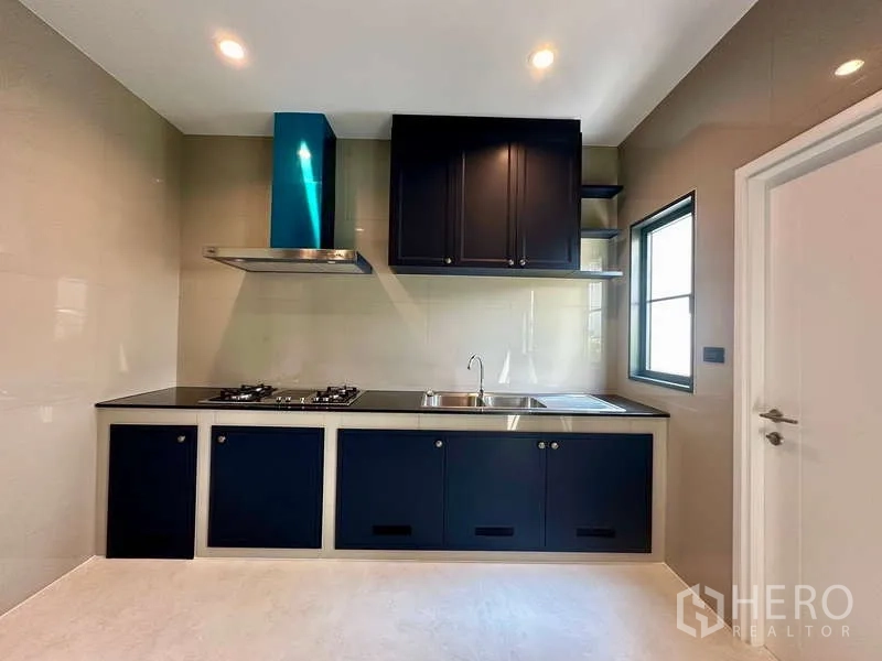 独立式住宅 出租在Bang Phli, Samut Prakan - 一字型厨房操作台，炉灶、水槽与吊柜。