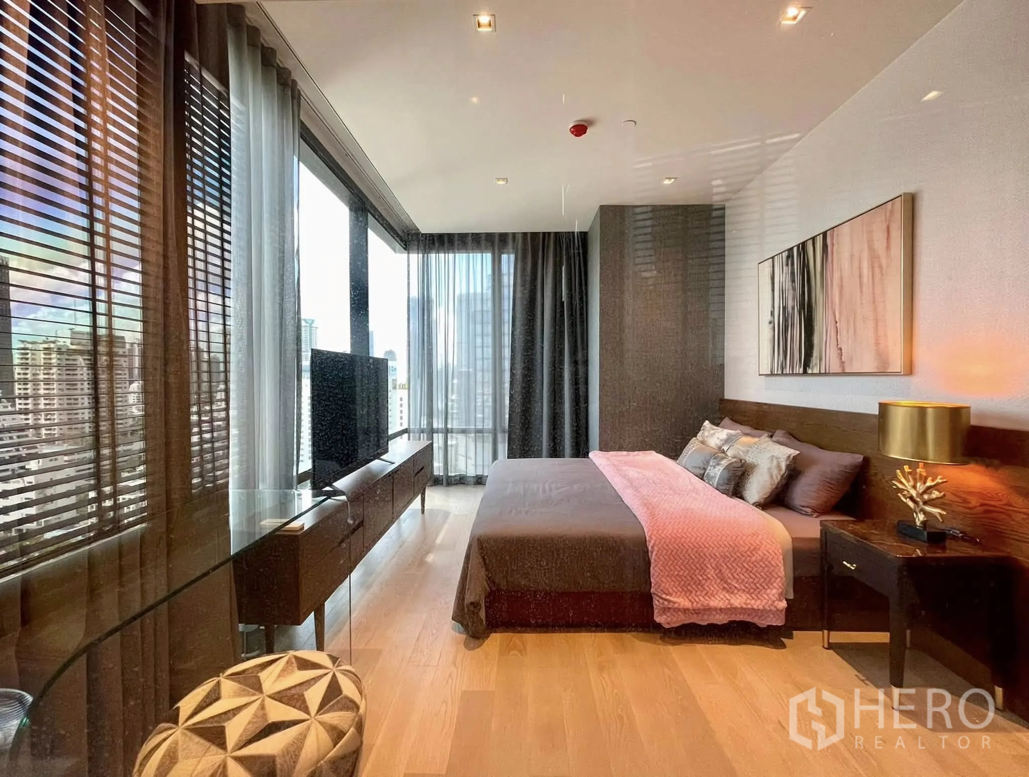Condominium for rent in Bang Rak, Bangkok - Master bedroom with wide windows, TV stand and city view.
