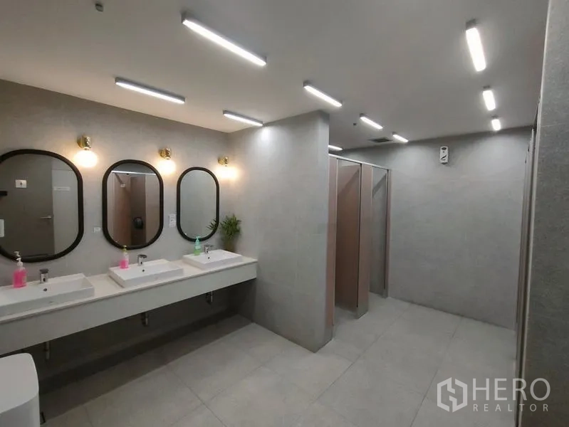 办公空间 出租在Bang Rak, Bangkok - 现代公共卫浴，多个洗手台与镜子，独立隔间，配色素雅。