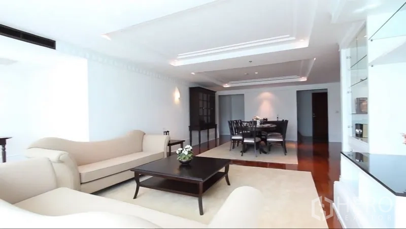 房间 出租在Khlong Toei, Bangkok - 开放式客餐厅，吊顶灯带、餐桌与嵌入式展示柜。