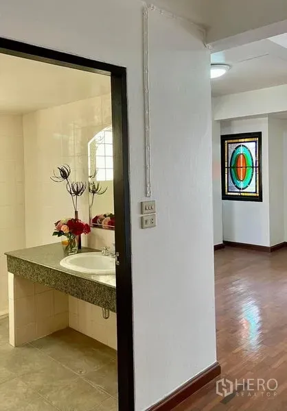 สำนักงานที่บ้าน ให้เช่าในKhlong Toei, Bangkok - ประตูห้องน้ำพร้อมเคาน์เตอร์หินแกรนิตและอ่างล้างหน้า ข้างโถงพื้นไม้