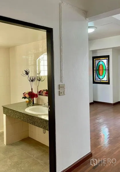 สำนักงานที่บ้าน ให้เช่าในKhlong Toei, Bangkok - ประตูห้องน้ำพร้อมเคาน์เตอร์หินแกรนิตและอ่างล้างหน้า ข้างโถงพื้นไม้