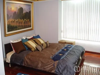 Condominium for rent in Pathum Wan, Bangkok - Primary bedroom with large window blinds, framed artwork and a low platform bed.