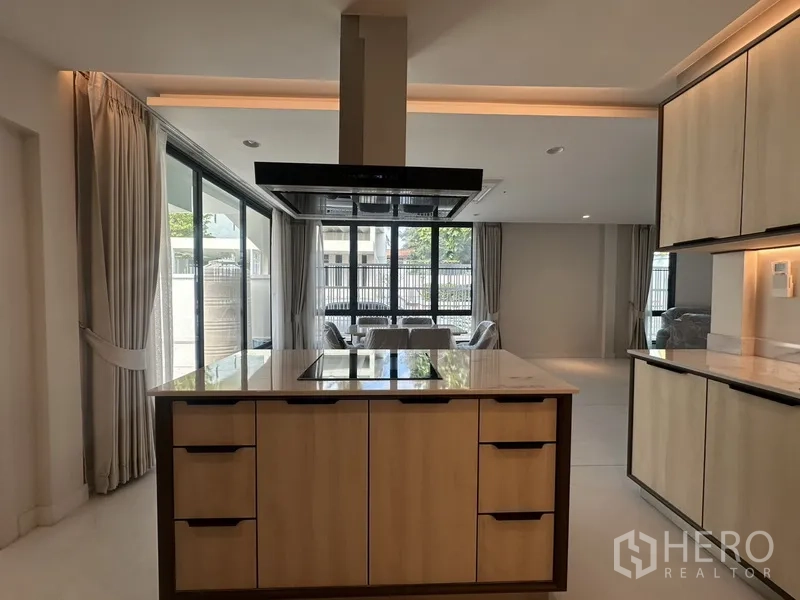 ทาวน์เฮาส์ ให้เช่าในWatthana, Bangkok - เตาอินดักชันบนไอส์แลนด์หันสู่ห้องนั่งเล่นและหน้าต่างบานใหญ่