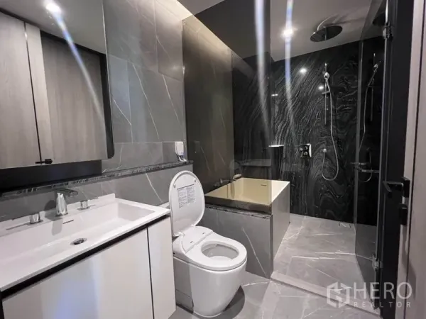 คอนโด ให้เช่าในKhlong Toei, Bangkok - ห้องน้ำสไตล์โมเดิร์น ผนังหินสีเทา อ่างอาบน้ำ แยกโซนฝักบัวเรนชาวเวอร์และเคาน์เตอร์อ่างล้างหน้า