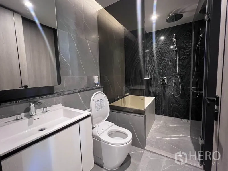 คอนโด ให้เช่าในKhlong Toei, Bangkok - ห้องน้ำสไตล์โมเดิร์น ผนังหินสีเทา อ่างอาบน้ำ แยกโซนฝักบัวเรนชาวเวอร์และเคาน์เตอร์อ่างล้างหน้า