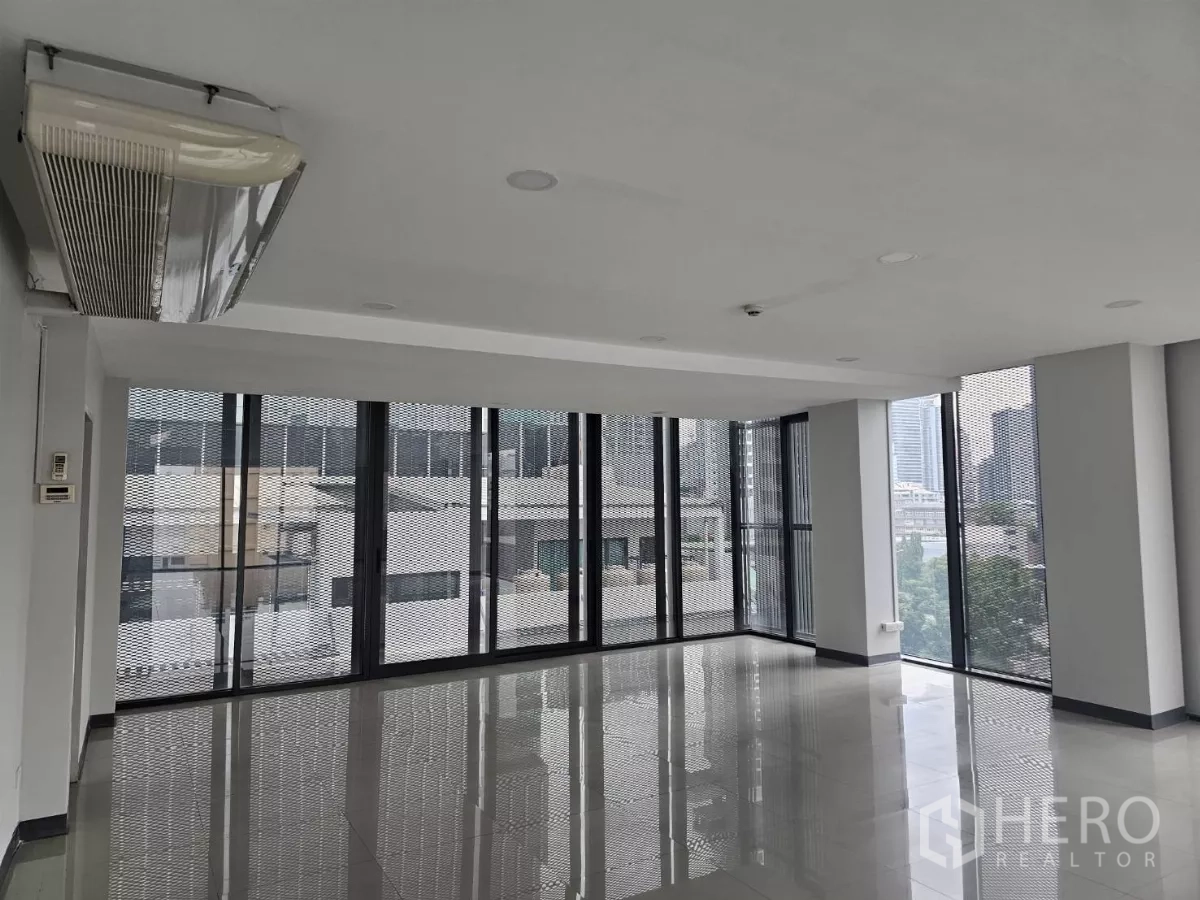 Office Space for rent in Sathon, Bangkok - Corner workspace with wraparound glazing, natural light and wall-mounted air-conditioning.