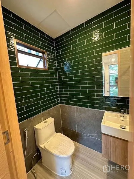 独立式住宅 出租在Bang Kapi, Bangkok - 客用卫生间，亮面绿色地铁砖与小型盥洗台。
