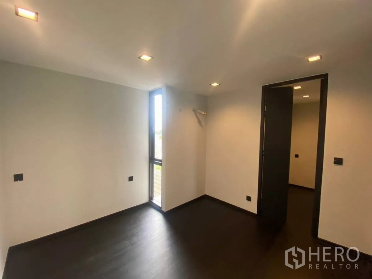 ทาวน์เฮาส์ ให้เช่าในHuai Khwang, Bangkok - ห้องนอนขนาดกะทัดรัด ไฟดาวน์ไลท์ พื้นสีเข้มและหน้าต่างมุมแคบ.