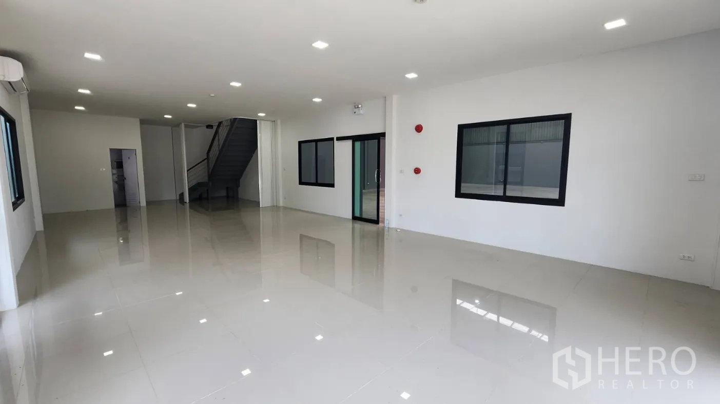 Factory for rent in Bang Bo, Samut Prakan - Open-plan office with white walls, glossy tile floor and a glass partition to the warehouse.